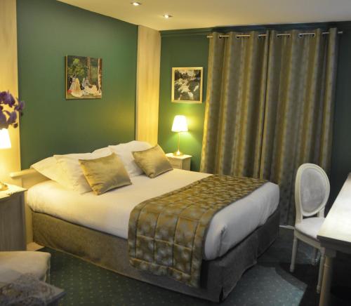 a hotel room with a bed with green walls at L'Hôtel Le Cheval Noir in Moret-sur-Loing