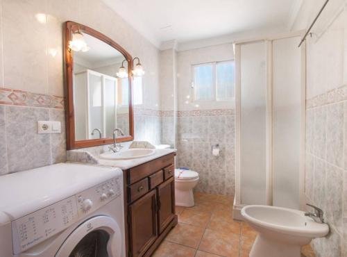 a bathroom with a washer and sink and a toilet at Villa Nerea - Plusholidays in Calpe