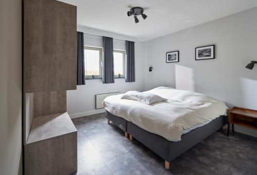 une chambre avec un grand lit et une fenêtre dans l'établissement Résidences Durbuy, à Durbuy
