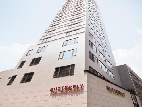 a tall white building with a butchery sign on it at Butterfly on Wellington, Central in Hong Kong