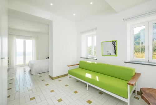 biały pokój z zieloną kanapą i łóżkiem w obiekcie Apollon Club & Thermal Spa w mieście Ischia