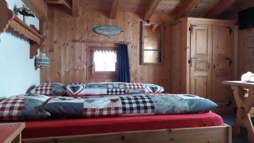 Una cama en una cabaña de madera con almohadas. en B&B Haus im Sand, en Davos