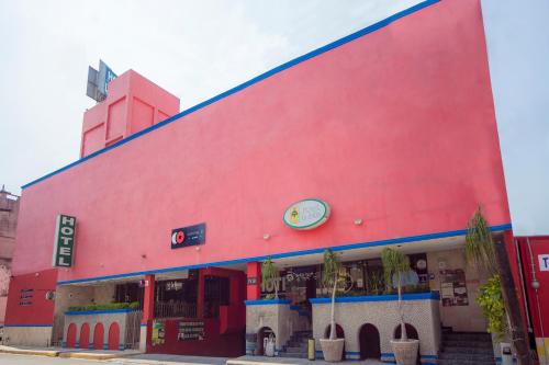 a red building with palm trees in front of it at Hotel La Silla in Monterrey