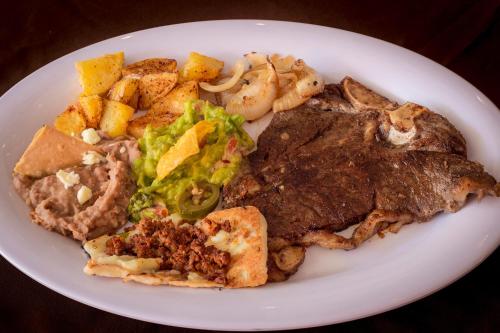 a plate of food with meat and vegetables on a table at Hotel La Silla in Monterrey