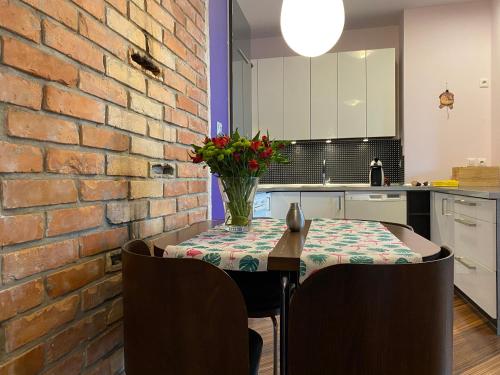 eine Küche mit einem Tisch und einer Ziegelwand in der Unterkunft Apartamenty Lemon Pepper in Jelenia Góra