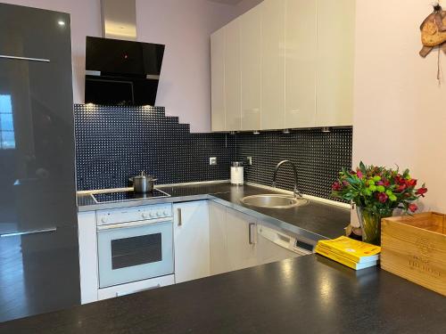 a kitchen with white cabinets and a sink at Apartamenty Lemon Pepper in Jelenia Góra
