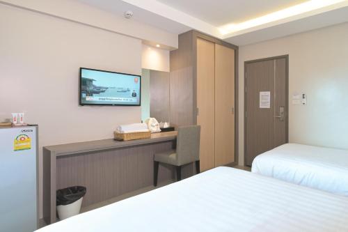 a hotel room with a desk and a tv on the wall at Sleep Hotel Bangkok in Bangkok