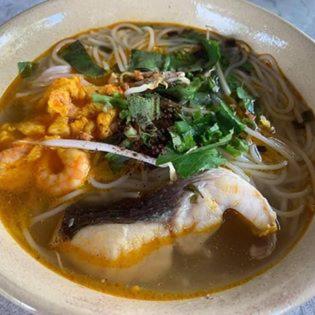 a bowl of soup with shrimp and noodles on a table at Bầu Bí Mini Farmstay Mekong - Tiền Giang in My Tho