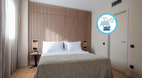 a bedroom with a large bed and a sign at Aparthotel Atenea Barcelona in Barcelona