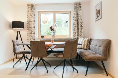 a living room with a table and chairs and a couch at Ferienhaus Alpen Lodge und die Gams in Neurur
