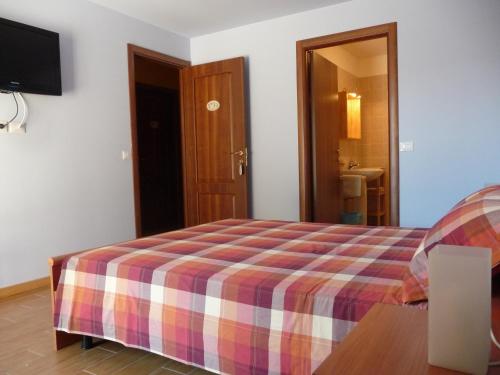 a bedroom with a bed with a plaid blanket at Villa Patrizia in San Canzian dʼlsonzo