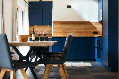 a kitchen with blue cabinets and a table with wine glasses at Ferienhaus Alpen Lodge und die Gams in Neurur