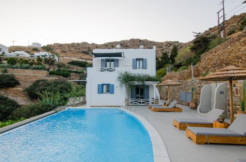 a villa with a swimming pool and a house at Gianemma Luxury Apartments in Mylopotas