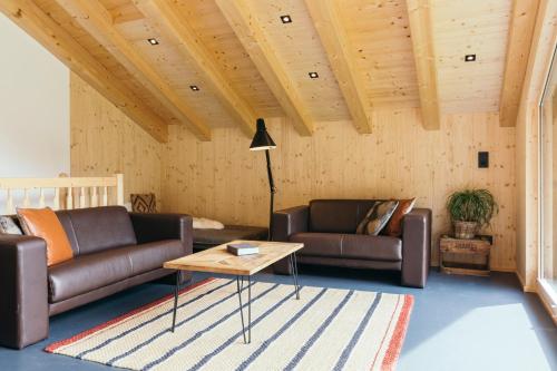a living room with two couches and a table at Ferienhaus Alpen Lodge und die Gams in Neurur