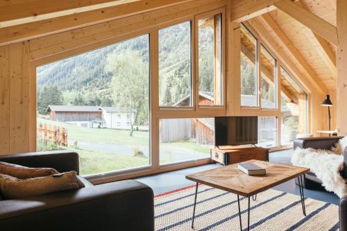 a living room with a large window in a cabin at Ferienhaus Alpen Lodge und die Gams in Neurur