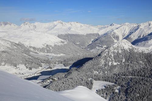 a view of a snowy mountain range with a lake at AlpenGold Hotel Davos in Davos