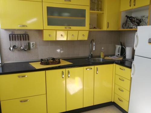 a kitchen with yellow cabinets and a sink at Apartman Gaga in Pirot