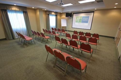 a conference room with red chairs and a screen at Holiday Inn Express Hotel & Suites CD. Juarez - Las Misiones by IHG in Ciudad Juárez