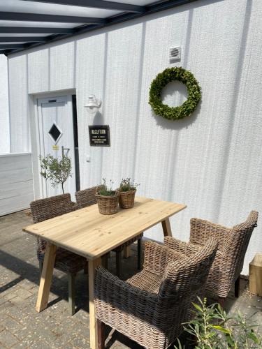 a wooden table with chairs and a wreath on a wall at Ferienhaus No. 4 in Perl