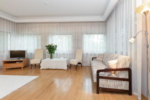 a living room with a couch and a tv at Valensija in Jūrmala