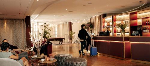 a man with a suitcase in a hotel lobby at Hotel Hasselbacken in Stockholm