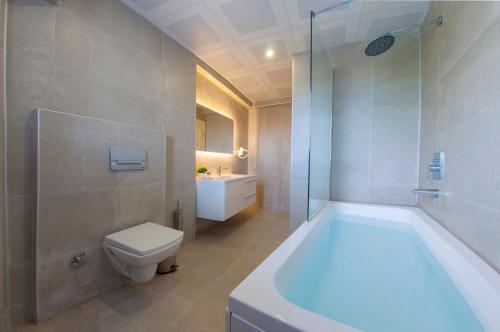 y baño con bañera, aseo y lavamanos. en Room Room Hotel, en Sapanca