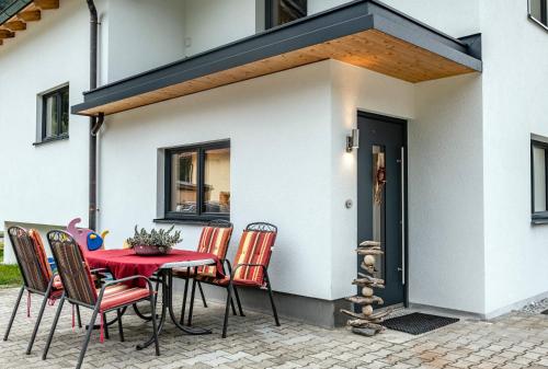 eine Terrasse mit einem Tisch und Stühlen vor einem Haus in der Unterkunft Ferienwohnung Bluamastiel in Schruns-Tschagguns