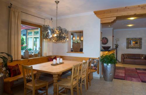 a dining room with a wooden table and chairs at Ferienappartements Landhof in Ellmau
