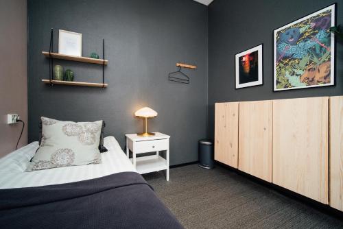 a bedroom with a bed and a night stand and a cabinet at The Yard Hostel in Helsinki