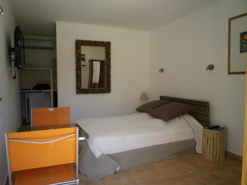 une chambre avec un lit et un miroir au mur dans l'établissement Chambres d'hôtes Villa Alizé, à Grimaud