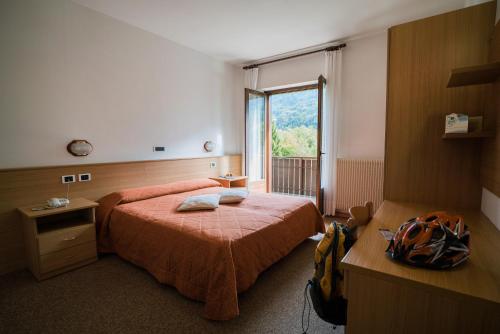 una camera d'albergo con letto e finestra di Hotel Rio a Caderzone