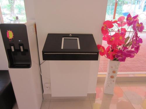 a cash register and flowers in a room at Merlin Hotel in Port Dickson