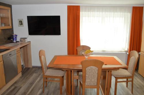 a kitchen and dining room table with chairs and a television at Ferienhaus Köhler in Marienberg