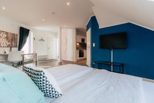 Un dormitorio con una pared de acento azul y una cama en Hentschels Apartments, en Leipzig