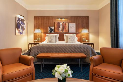 a hotel room with a bed and two chairs at Hôtel Barrière Le Westminster in Le Touquet-Paris-Plage