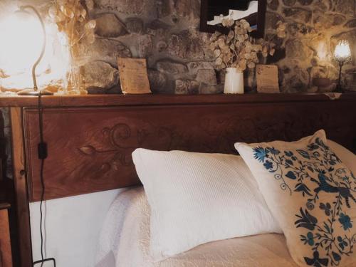 a bed with a wooden headboard with a pillow and a lamp at Casa Lucia in Mogarraz