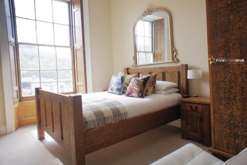 Schlafzimmer mit einem Bett und einem Spiegel an der Wand in der Unterkunft Windsor Street Apartment in Edinburgh