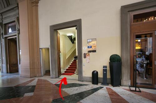 einen Flur mit einem roten Pfeil auf dem Boden eines Gebäudes in der Unterkunft Mabelle Firenze Residenza Gambrinus in Florenz