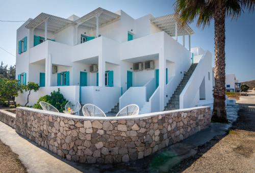 a white house with a stone wall at Michalis Studios in Pollonia