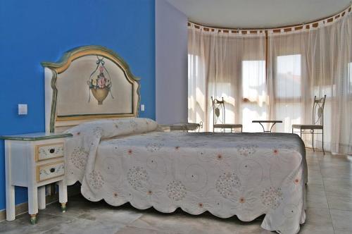 a bedroom with a large white bed and blue walls at Apartamentos Quinto Sueño in Noja