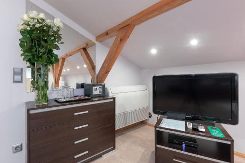 a living room with a large television on a dresser at Valensija in Jūrmala