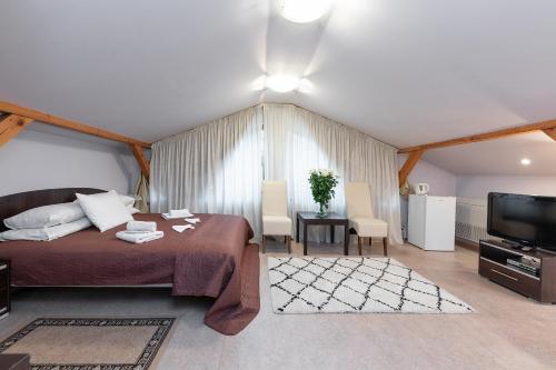 a bedroom with a bed and a tv in a room at Valensija in Jūrmala