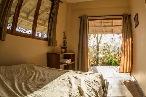 a bedroom with a bed and a large window at Hotel Kambutaleko in Cambutal