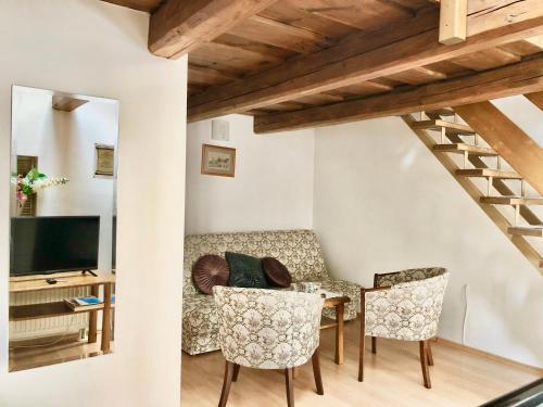 a living room with a couch and a table and chairs at Maria Penzion & Restaurant in Trenčín