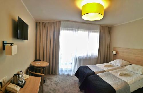 a hotel room with a bed and a window at Hotel ***NAT Sarbinowo in Sarbinowo