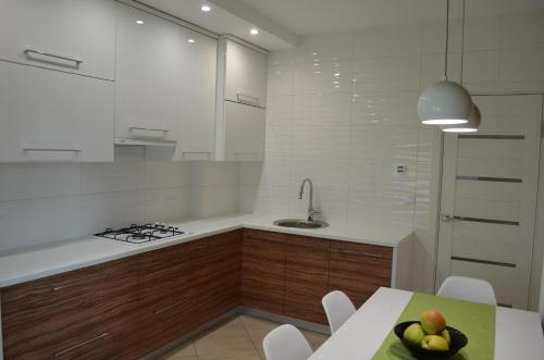 a kitchen with a table with a bowl of fruit on it at Apartment on Getmana Vigovskogo 49 in Rivne