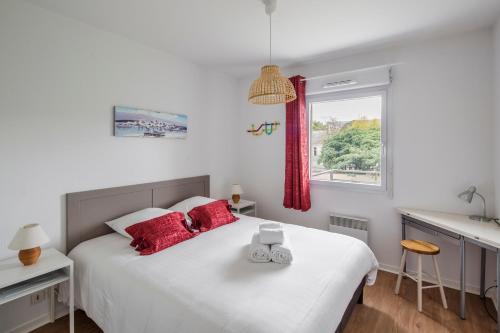 a bedroom with a bed with red pillows and a window at Les Petites Canailles - Proche de la Gare in Nantes