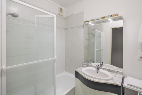 a white bathroom with a sink and a shower at Les Petites Canailles - Proche de la Gare in Nantes