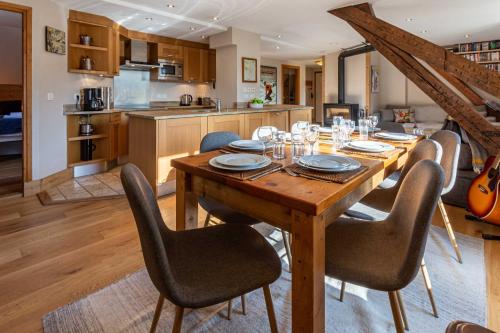 une table de salle à manger avec des chaises et une cuisine dans l'établissement La Belle Epoque - Chamonix All Year, à Chamonix-Mont-Blanc