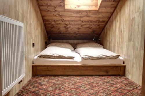 - un petit lit dans une petite chambre située dans une maison dans l'établissement Chata Styl, à Hlinsko